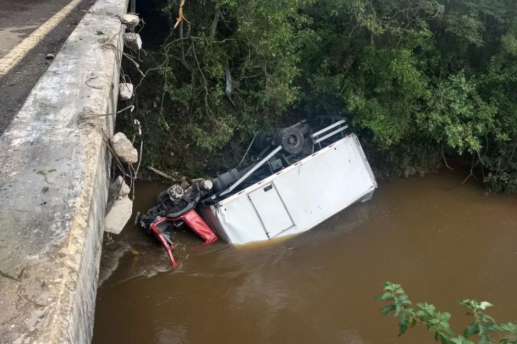 Caminhão cai em rio, e motorista fica preso e submerso até o pescoço em MG